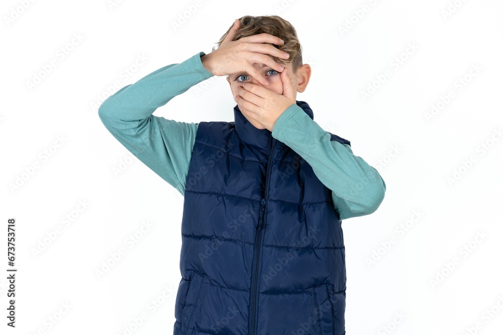 Caucasian teen boy Covering eyes and mouth with hands, surprised and shocked. Hiding emotions. Caucasian teen boy Covering eyes and mouth with hands, surprised and shocked. Hiding emotions.