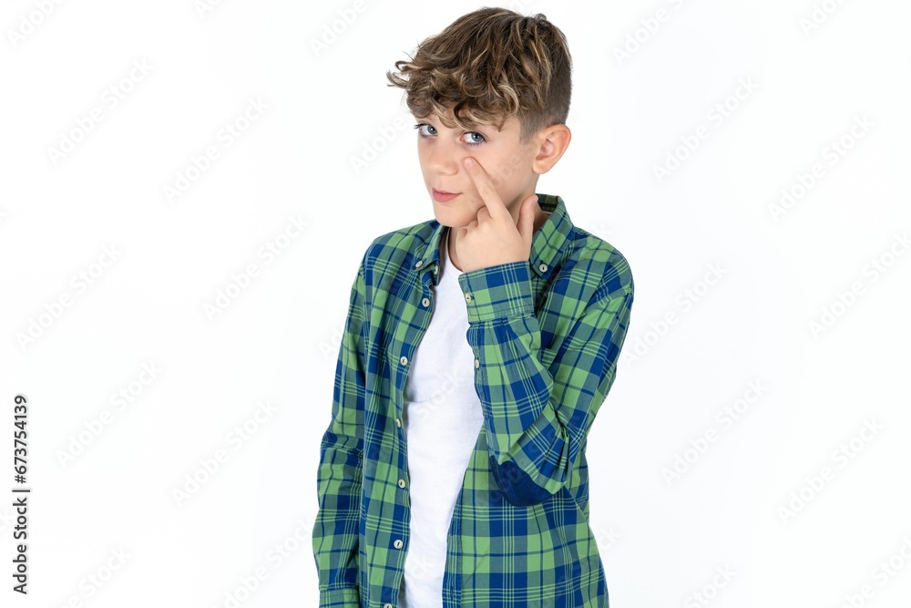 Caucasian teen boy Pointing to the eye watching you gesture, suspicious expression. Caucasian teen boy Pointing to the eye watching you gesture, suspicious expression.