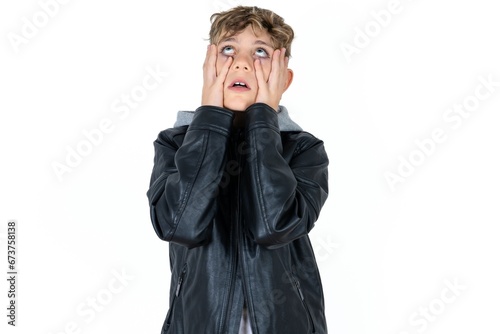 Caucasian teen boy keeps hands on cheeks has bored displeased expression. Stressed hopeless model