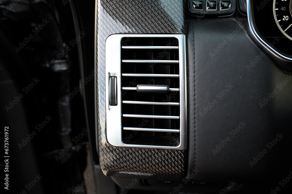 Lux SUV Car air vents close-up grille. Air ventilation grille with power regulator. Premium  Car air conditioner, interior of a new modern car.