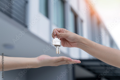 Foto Real estate agent delivering keys house, Hands pass a house key as a symbol of real estate and house buying