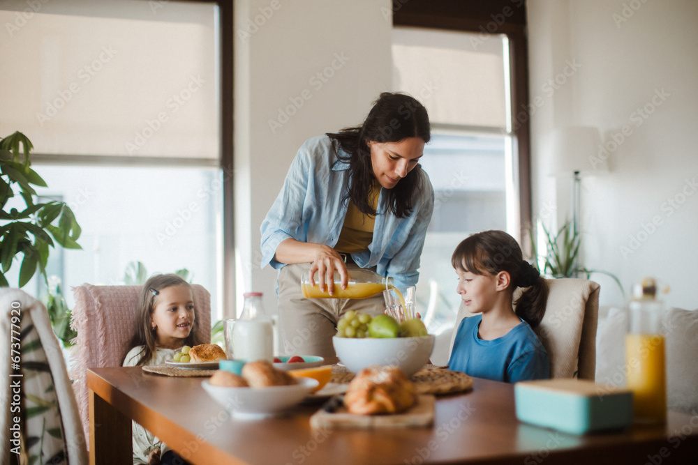 Mother prepares breakfast for children, in the morning. Maternal love and care for household and family. Mother prepares breakfast for children, in the morning. Maternal love and care for household and family.