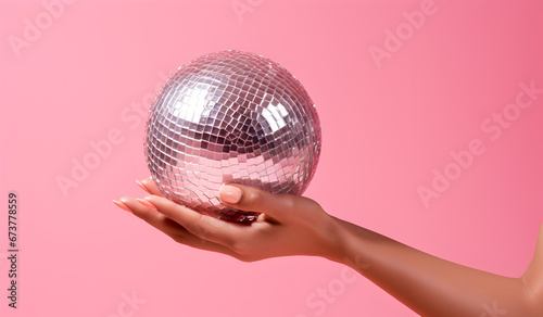 Hand Holding Giant Disco Ball on Pink Background - Season's Greetings Concept