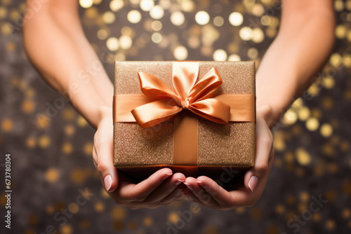 a woman hand holding a luxury gift box with bow against a christmas background, Woman holding beautiful gift box against blurred festive lights, closeup © Planetz
