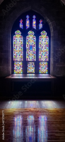Vertical of a stained glass window in a dark room © Wirestock