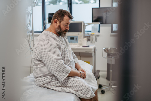 Photos Overweight patient in hospital gown waiting for medical examination, test results in hospital, feeling anxious
