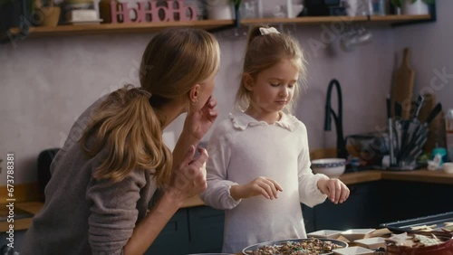 Mother and daughter eating homemade gingerbreads with chocolate. Shot with RED helium camera in 8K.