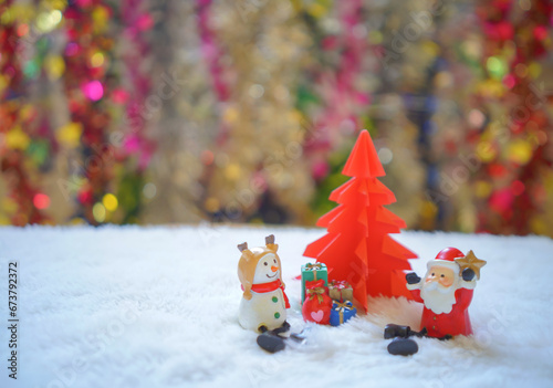  Sata and snowman sitting on white snow with group of gifts  in front of red origami Christmas tree waiting for funny festival, Christmas and New Year concept. photo