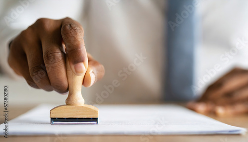 Closed up businessman hand using wooden stamping to document