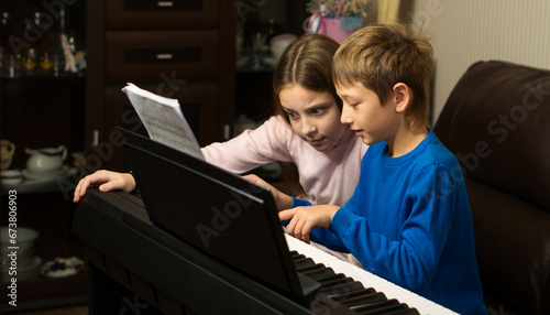 Fotografie Siblings Sharing Piano Moments