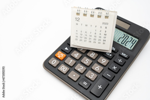 Calculator with the number 2024 on the display and Calendar DEC 2023. Concept of finance, taxes, savings and economic crisis. schedule, timetable and management of job. Business and tax concept.