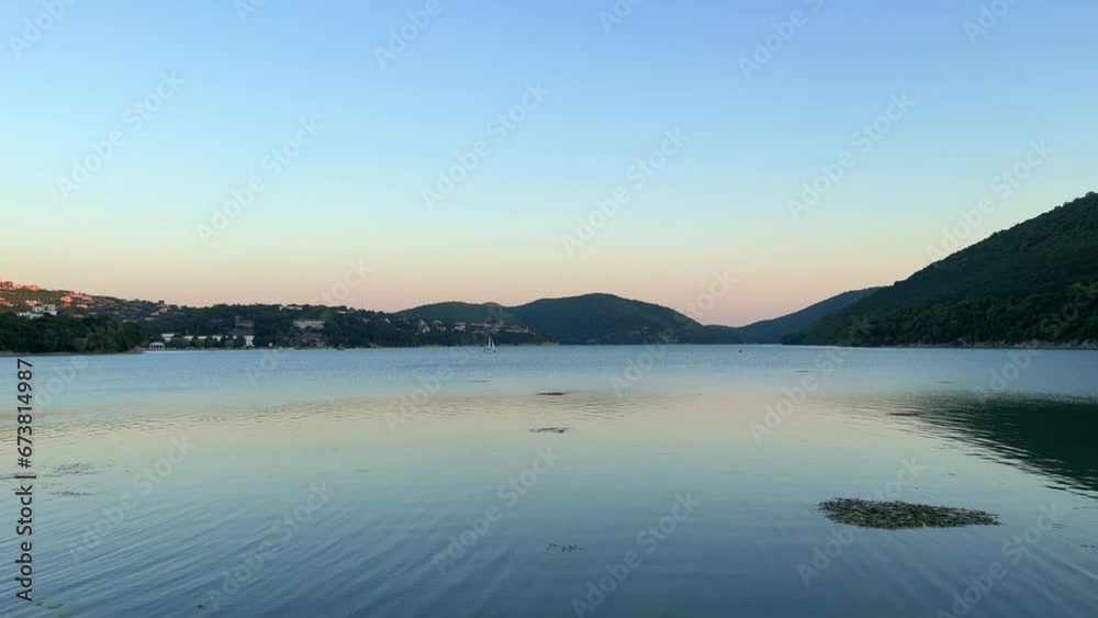 Lake Abrau in the village of Abrau-Durso, Russia. Fountain on a mountain lake on a summer morning. Russia. Light ripples on the calm surface of the water. Summer natural landscape. 4K Lake Abrau in the village of Abrau-Durso, Russia. Fountain on a mountain lake on a summer morning. Russia. Light ripples on the calm surface of the water. Summer natural landscape. 4K