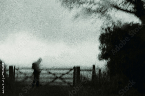 A spooky mysterious ghostly figure On a bleak winters day. in the countryside. With an abstract, grunge, blurred edit.