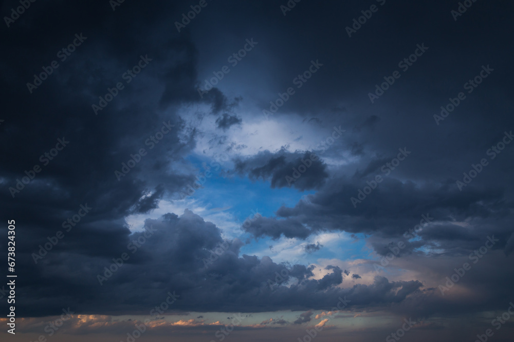 Naklejka premium Epic Dramatic storm dark blue grey cumulus rain clouds on blue sky background, thunderstorm