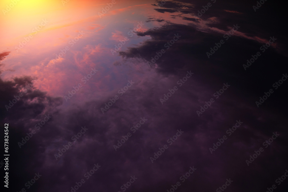 Sunrise, sunset above planet Earth from space, epic storm sky with dark violet pink clouds, orange yellow sun and sunlight. View from space over thunderstorm rain clouds