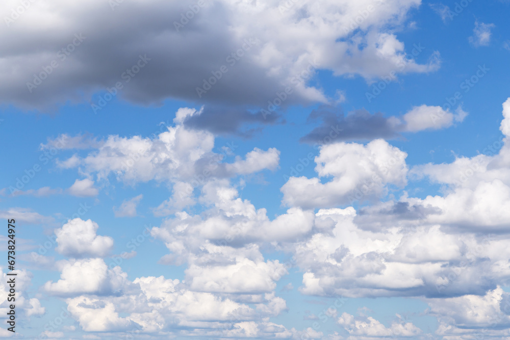 Light blue cloudy sky with many beautiful white fluffy cumulus clouds in sunlight abstract background texture Light blue cloudy sky with many beautiful white fluffy cumulus clouds in sunlight abstract background texture