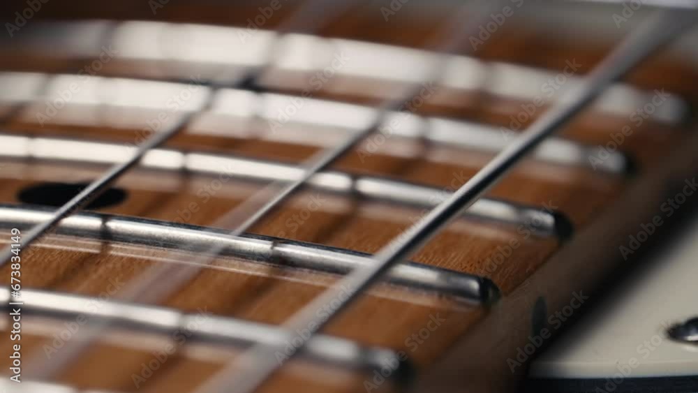 Electric guitar strings vibrating. Playing on music instrument. Sound waves, strumming chords, acoustic sound resonance. Super macro footage. Electric guitar strings vibrating. Playing on music instrument. Sound waves, strumming chords, acoustic sound resonance. Super macro footage.
