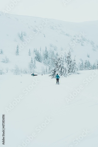 two people are snow skiing in the snow near a snowy mountain