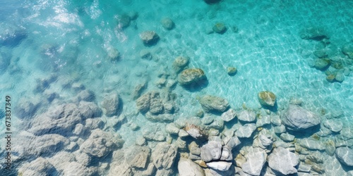 Aerial view of crystal clear water and rocky beach. Abstract seascape background. Summer vacation concept.