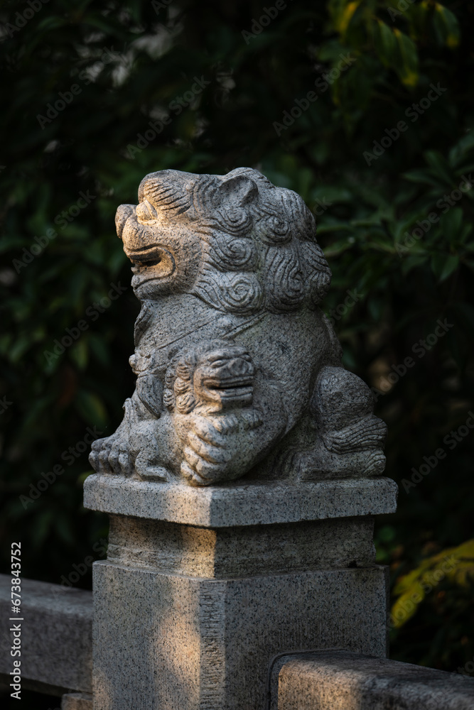 a stone lion statue illuminated by the sun