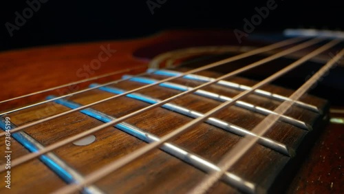 Acoustic guitar strings vibrating. Playing on classic music instrument. Sound waves, strumming chords, sound resonance. Super macro slider footage.