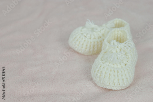 Baby shoes on pink fabric background