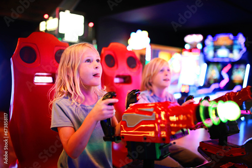 Fotografía Little Kids Playing Shooting Game Challenge at Video Arcade