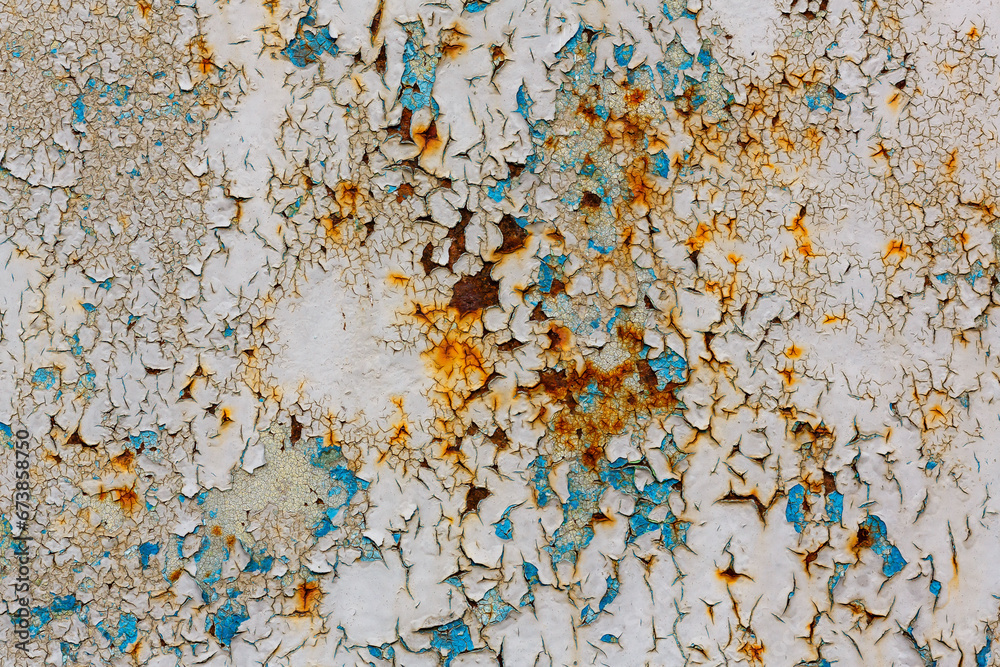 Rusty metal surface with cracked background paint. The texture of cracked paint