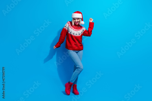 Full length photo of pretty shiny woman santa elf wear ornament pullover dancing x-mas party isolated blue color background
