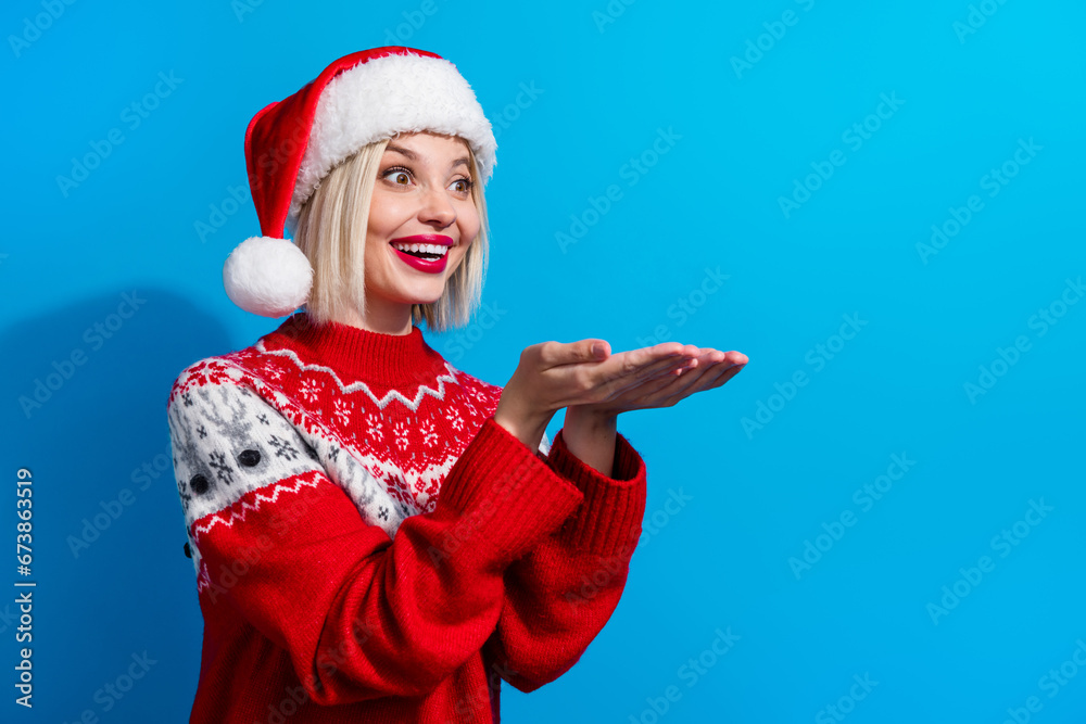 Obraz premium Photo of funky positive lady santa helper dressed ornament sweater holding arms empty space isolated blue color background