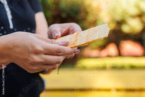 Woman's hand holds long chips, snack and fast food concept. Selective focus on hands with blurred background