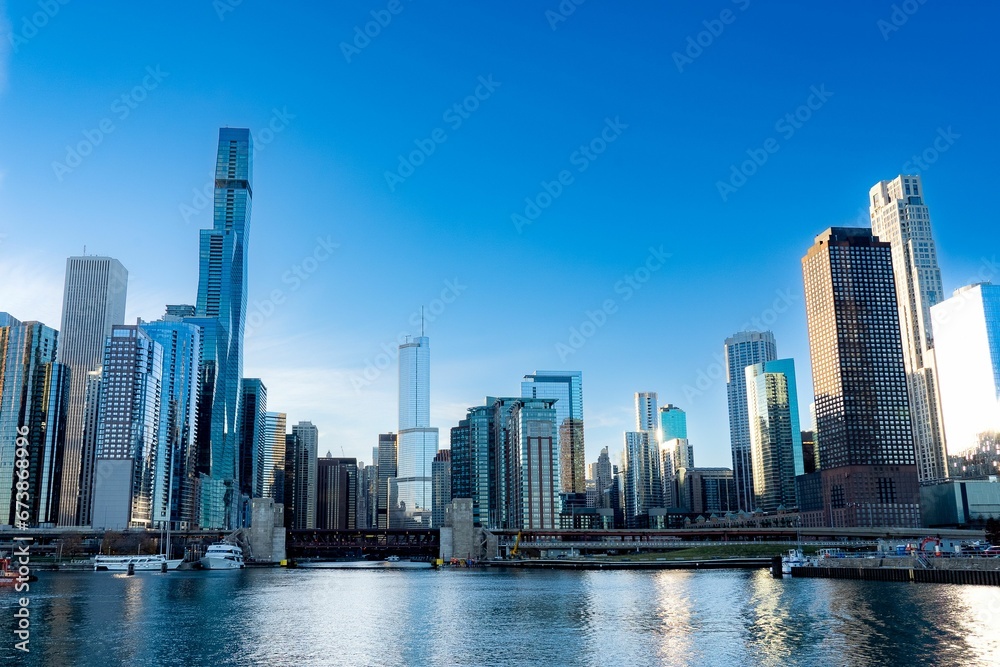 Cityscape of Chicago with the lake in the foreground and a clear blue sky in the background.