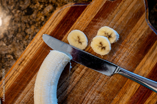 Selective focus on slices of a bananas on a wooden cutting board