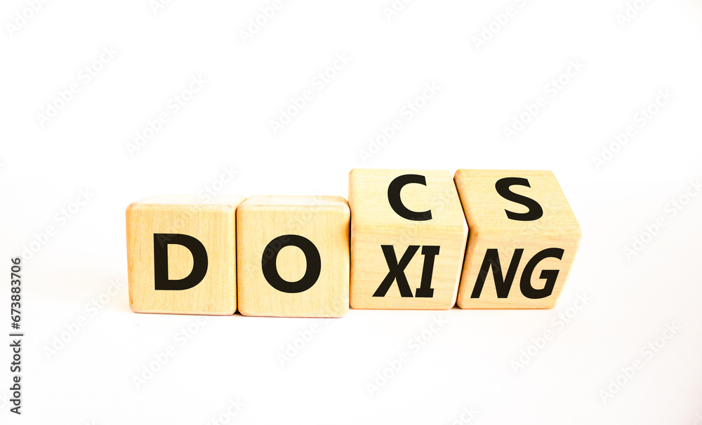 Docs or doxing symbol. Concept words Docs Doxing on wooden block. Beautiful white table white background. Business docs or doxing concept. Copy space. Docs or doxing symbol. Concept words Docs Doxing on wooden block. Beautiful white table white background. Business docs or doxing concept. Copy space.