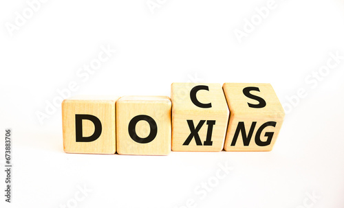 Docs or doxing symbol. Concept words Docs Doxing on wooden block. Beautiful white table white background. Business docs or doxing concept. Copy space.