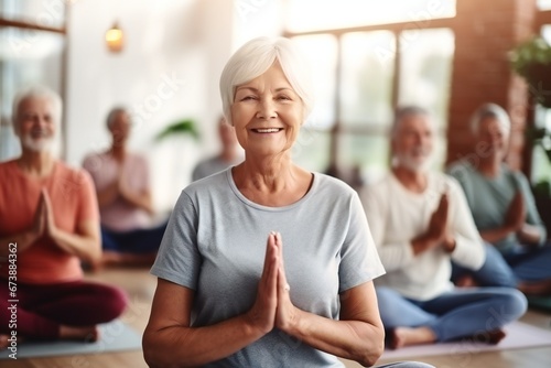 a group of active elderly people perform yoga together indoors, to improve their physical condition and well-being, and to socialize with each other, active aging concept