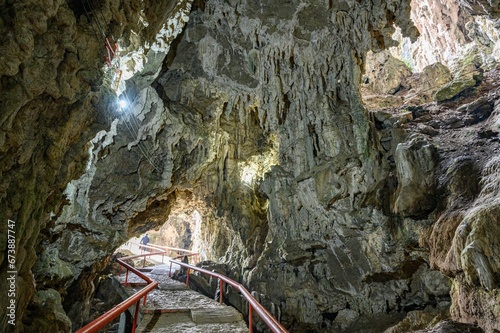 there is a long wooden stair in a cave with large rocks