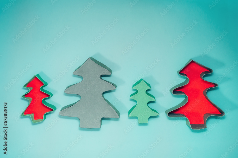 Top view empty Christmas gift boxes in the shape of Christmas trees on the turquoise background. Craft gift box packaging ideas. Christmas presents delivery service. Flat lay, copy space. Top view empty Christmas gift boxes in the shape of Christmas trees on the turquoise background. Craft gift box packaging ideas. Christmas presents delivery service. Flat lay, copy space.