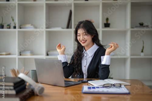 Freelance Asian woman enjoying video call on her laptop Remote work and communications.