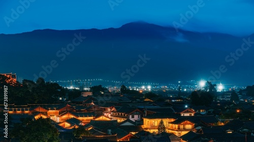 the lights on a town in the distance and mountains in the distance © Wirestock