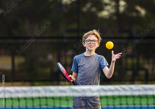 Boy playing pickleball on court