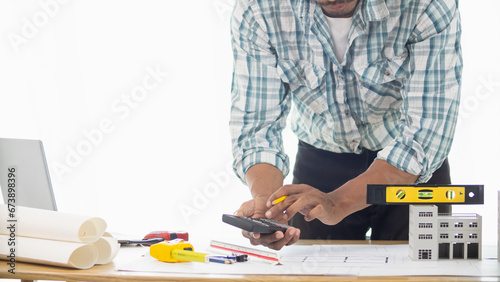 Fototapeta Naklejka Na Ścianę i Meble -  Construction engineers are checking blueprints and calculating their accuracy after receiving plans from architect in order start  construction safely. Inspection Concept from construction engineering
