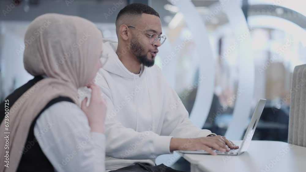 In a modern office setting, an African American businessman and his Muslim colleague, wearing a hijab, engage in collaborative discussions, tackling various business tasks and solving problems In a modern office setting, an African American businessman and his Muslim colleague, wearing a hijab, engage in collaborative discussions, tackling various business tasks and solving problems