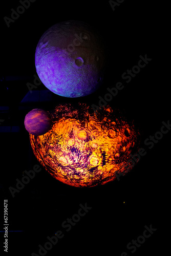 Photography of orange and purple planets closing to each other in dark black background