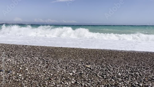 Powerful sea waves are crashing on coast. Waves splash on the beach with pebbles during a storm. Storm at sea.
