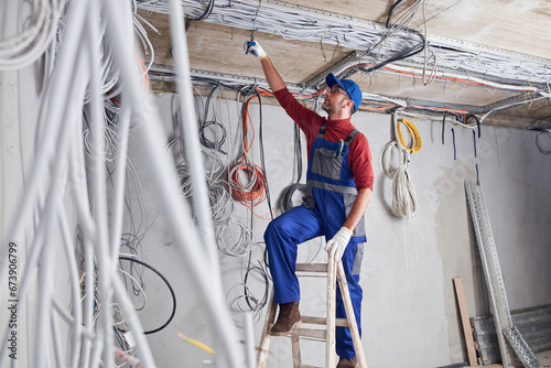 Electrician working on a wire system on a construction site.