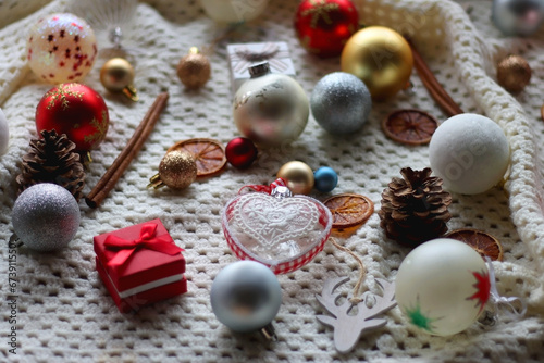 Various colorful Christmas ornaments, small presents and seasonal spices on white knitted blanket. Selective focus. © jelena990