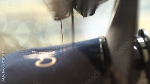 Automatic sewing machine needle in work process. Close-up of sewing machine needle in motion rapidly moves up and down. photo