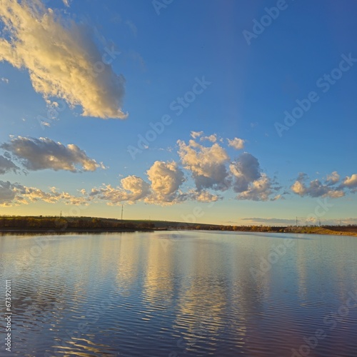 A body of water with clouds in the sky above it © parpalac