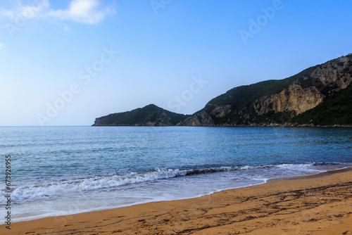 Sandy beach by the sea near Agios Georgios on the island of Corfu under a blue sky